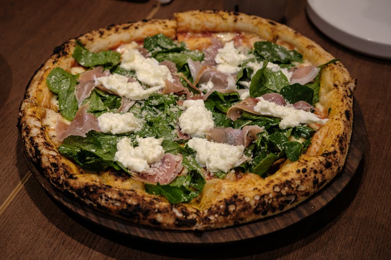 Prosciutto Arugula pizza with shaved parmesan